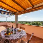 Terrazza panoramica di Casa Mirador con tavolo da pranzo e vista sulla campagna e sul mare