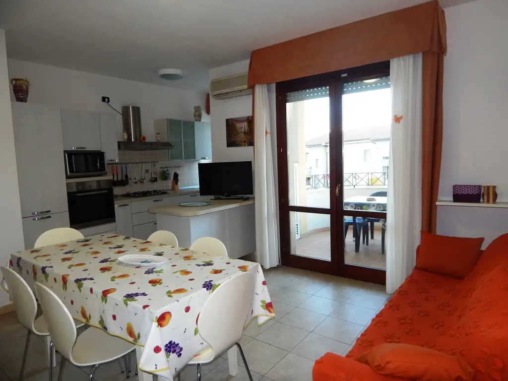 Soggiorno con cucina attrezzata e accesso al balcone del Trilocale Gemelli 2