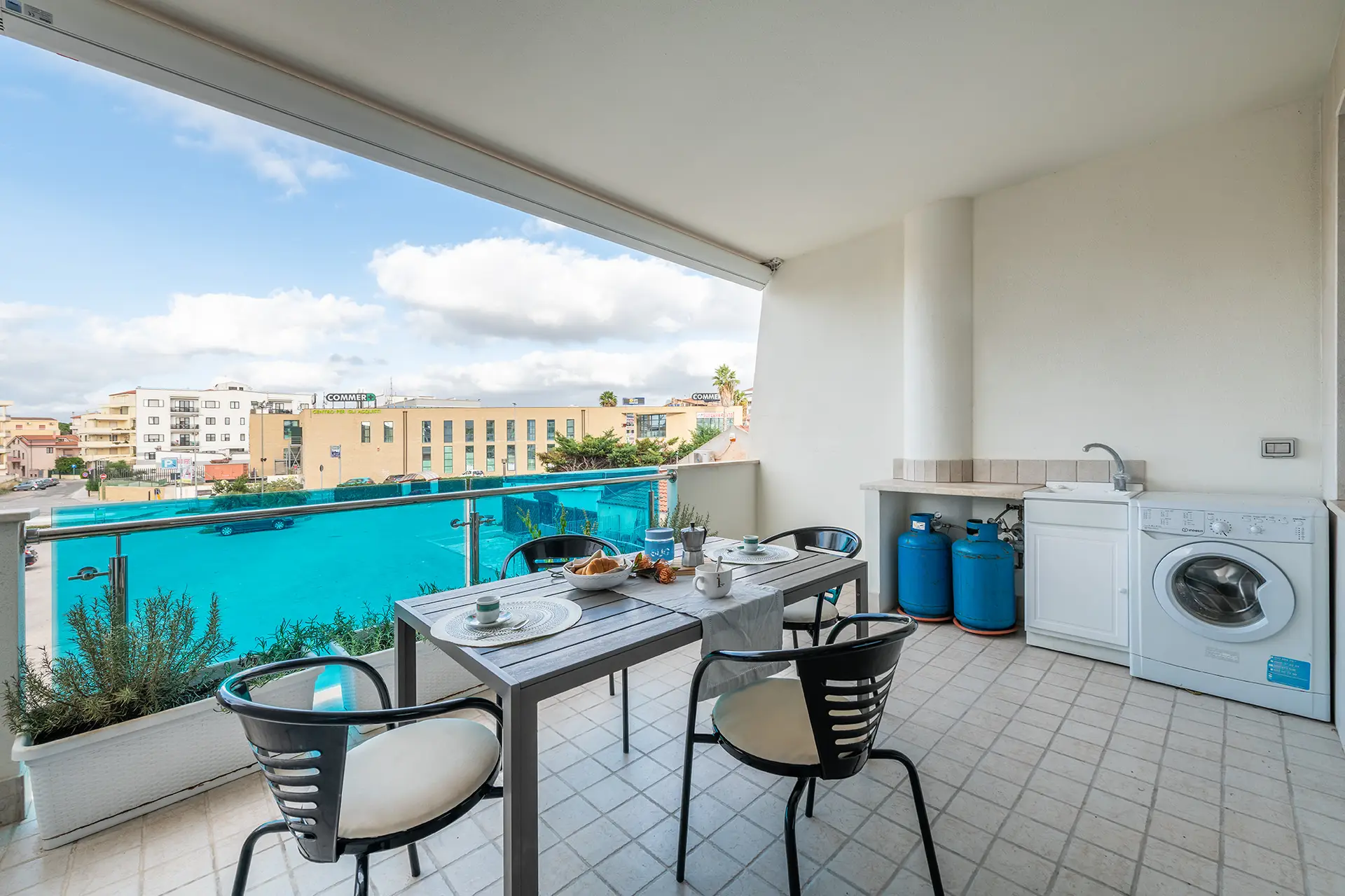 Balcone attrezzato con tavolo da pranzo e zona lavanderia di Casa del Lido
