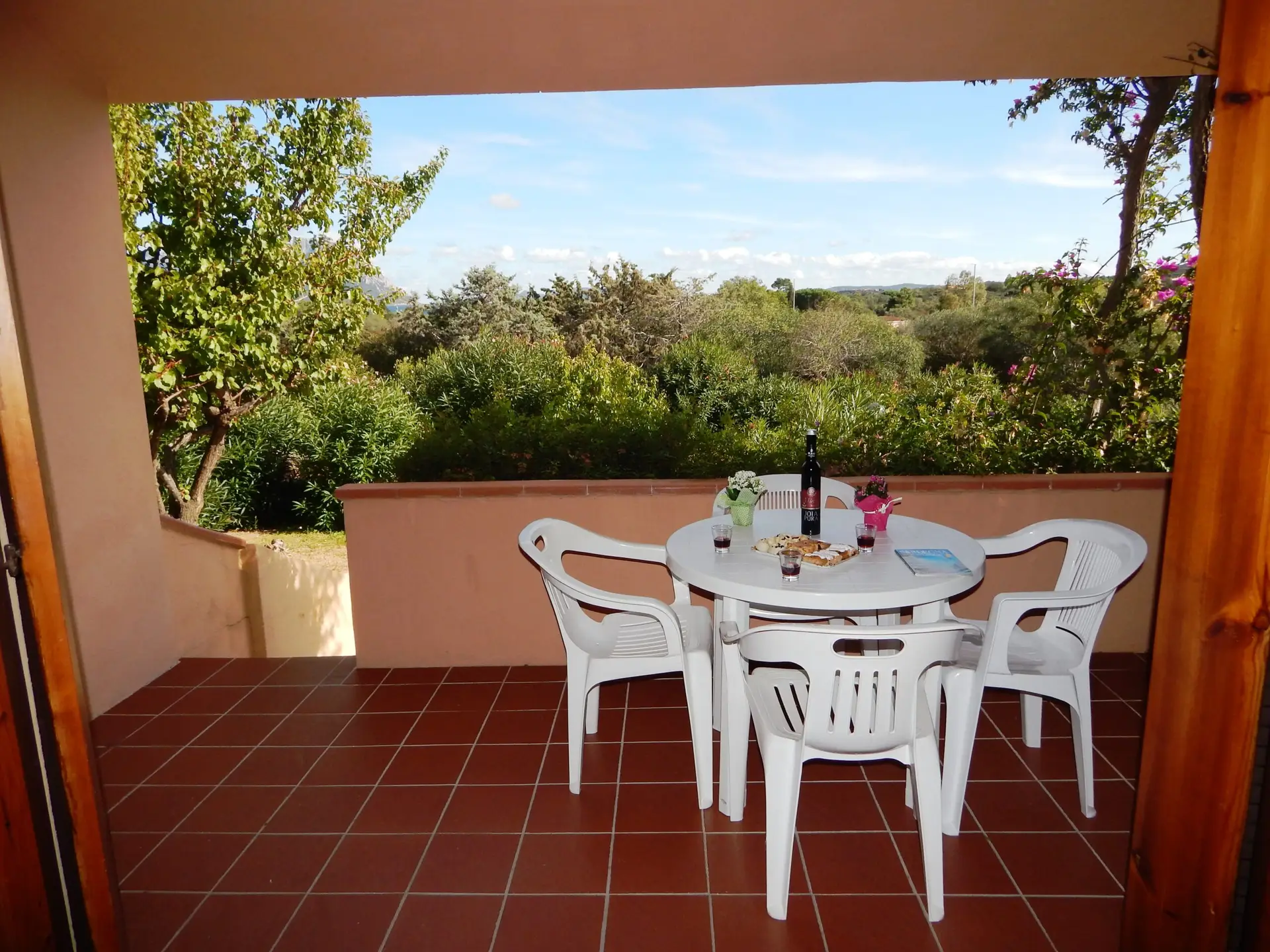 Veranda coperta del Bilo Istana con tavolo da pranzo e vista sul verde