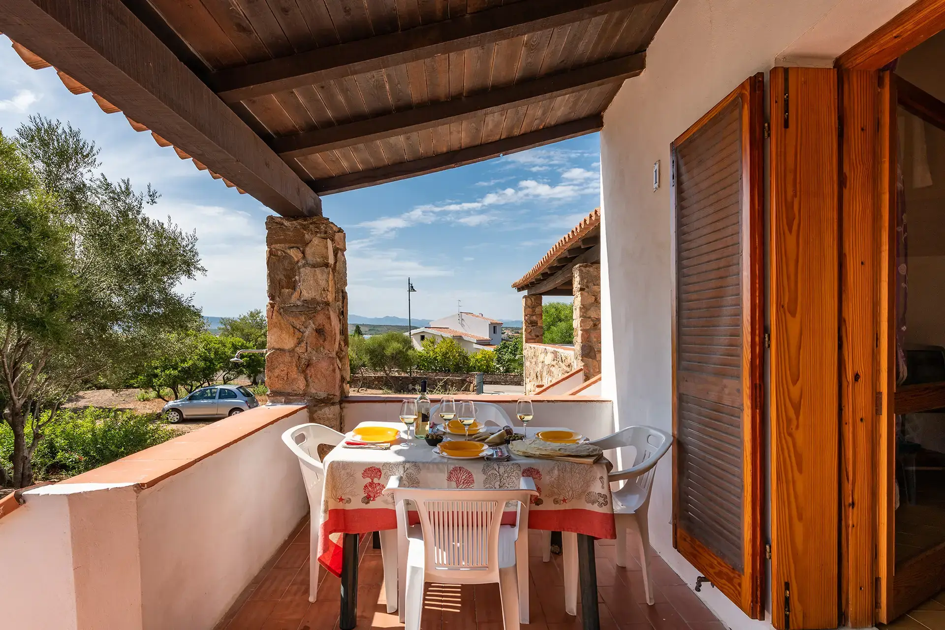 Veranda attrezzata del Bilo Carabi 2 a Pittulongu con tavolo da pranzo esterno