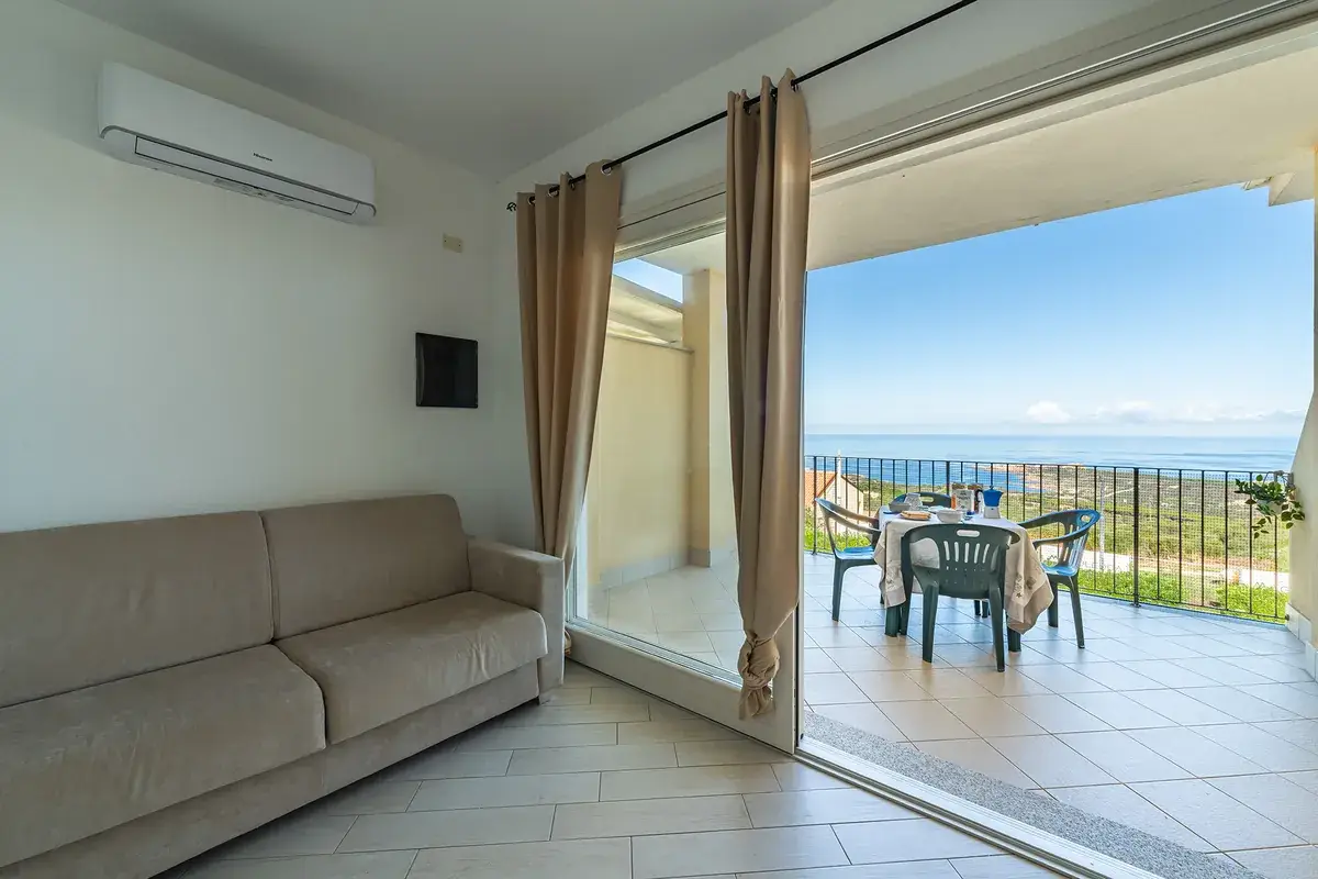 Soggiorno di Casa Pesca con accesso alla terrazza e vista mare in Sardegna
