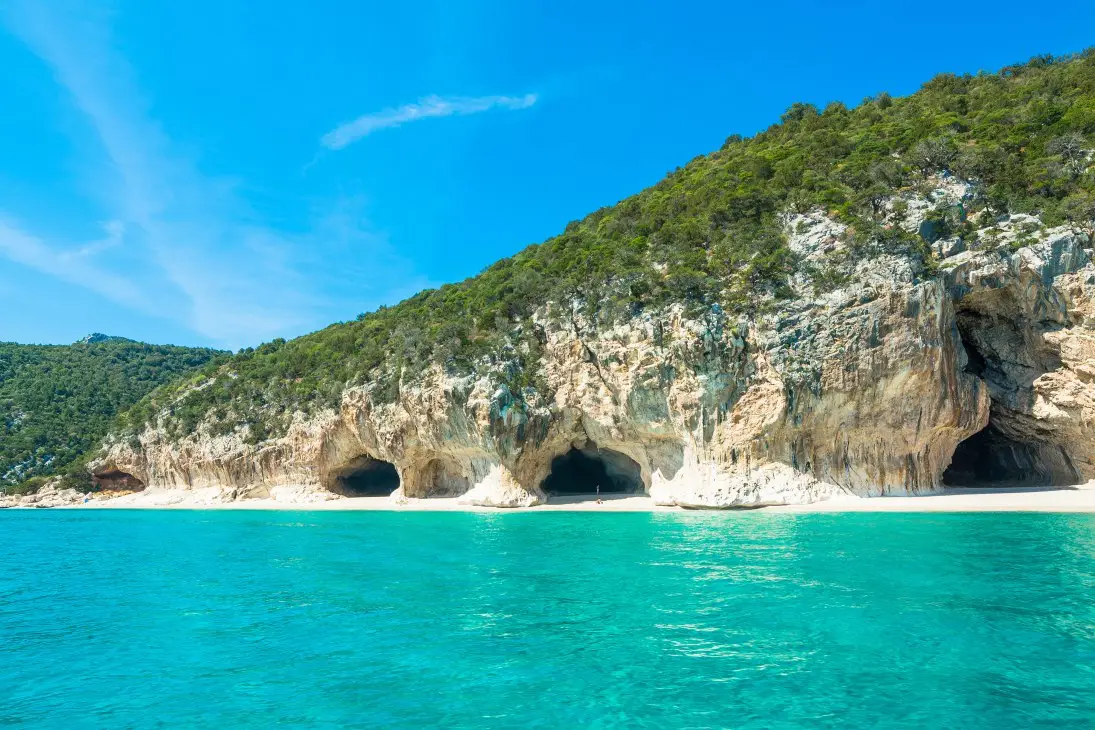 Cala Luna con le grotte nella falesia calcarea e il mare turchese, Golfo di Orosei, Sardegna