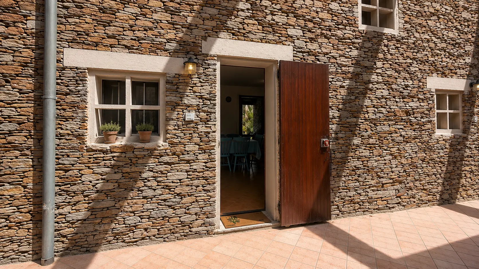 Ingresso in pietra con porta in legno della Casa dei Pini a Stintino, Sardegna